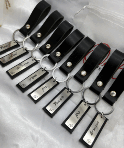 מחזיקי מפתחות בחריטה אישית עם רקע של רצועת עור שחורה